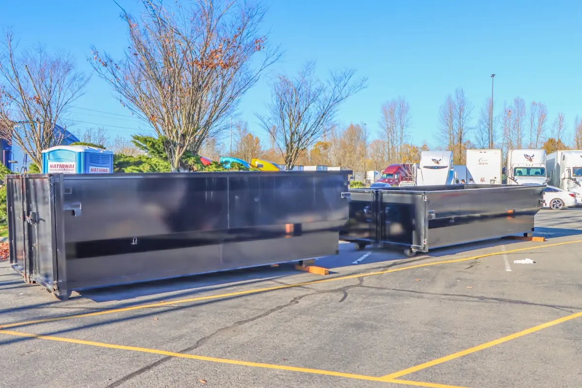 Professional dumpster rental service with roll-off container on residential driveway in Woodfield